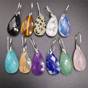 Detailed view of faceted teardrop gemstone earrings in multiple natural colors