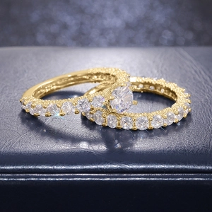 Close-up of gold double ring set with large center zircon and pave diamond accents