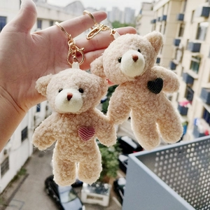 Pair of plush teddy bear keychains with striped heart patches and golden lobster clasps