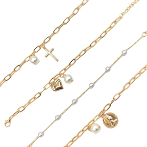 Detail of 4-piece gold bracelet set with pearls, cross, heart, and coin charms