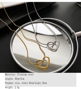 Detail of titanium steel hollow heart pendants in gold and silver with snake chains