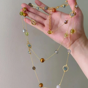 Vintage style colorful crystal beaded necklace with gold chain held in hand