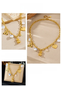 Detail of gold chain necklace with 3D bears, floral beads, pearls and heart charms