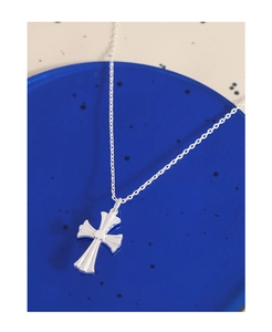 Macro shot of silver cross pendant with fine chain on blue translucent display stand