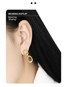 Close-up of geometric gold double-loop earrings with micro-pave diamonds on model