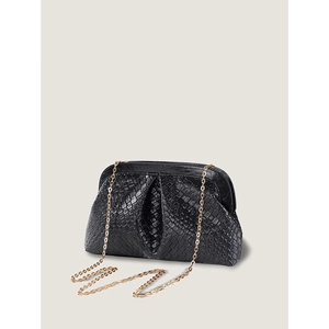 Detail of black woven cloud dumpling bag with elegant gold chain strap in soft light
