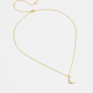 Detail of S925 silver gold-plated moon necklace featuring an opal stone and small crystals