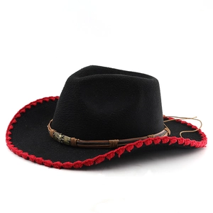 Détail d'un chapeau de cow-boy noir avec coutures rouges et ornement tête de mort