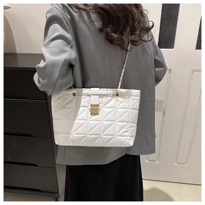 Detailed view of white quilted PU leather tote bag with gold chain and metal lock clasp