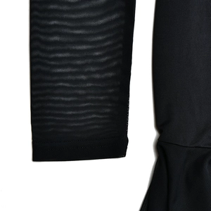 Detail of mesh cuffs and ruffled gauze hem on a black bodycon fishtail dress