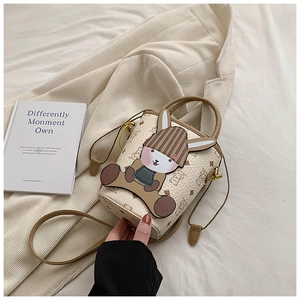 Detail view of a cute rabbit bucket bag in cream and brown PU leather on a soft background
