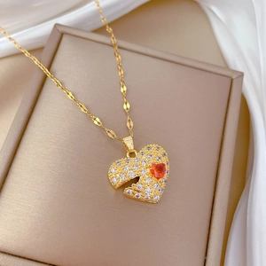 Luxurious gold heart pendant necklace with red gemstone and pavé diamonds on silk