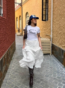 Detail of white tiered long skirt and graphic t-shirt in a retro vacation style