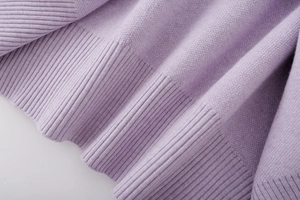 Detailed macro view of the ribbed cuff and knit texture on this light purple cardigan