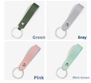 Detail view of four textured faux leather keychains in green, grey, pink, and mint colors