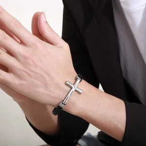 Bracelet pour homme en cuir tressé avec croix argentée porté sur poignet élégant