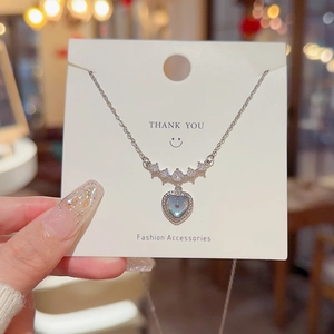 Exquisite silver heart pendant necklace with shimmering zircon stones on a white card