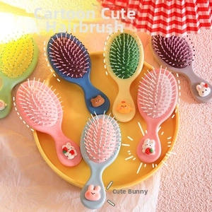 Close-up of colorful cartoon animal air cushion massage combs in a yellow tray