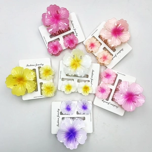 Detail showing marble textured frangipani flower hair claw set in assorted colors