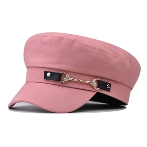Pink newsboy cap with black leather strap and rhinestone heart buckle detail