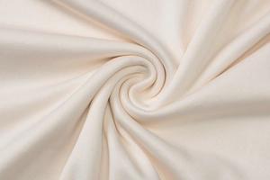 Détail macro du tissu en maille crème avec motifs en spirale doux pour haut ajusté
