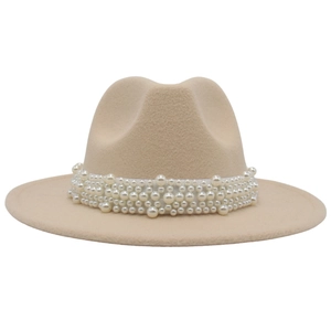 Close-up of elegant beige fedora with wide brim and decorative white pearl band