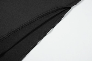 Detail of flat seam stitching and side slit on high-quality black dress fabric