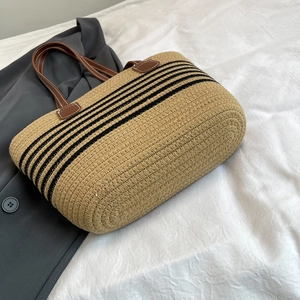 Grande borsa tote in paglia intrecciata con strisce nere e manici in pelle marrone vista