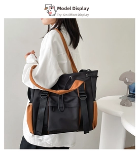 Detail of color-block nylon tote bag showing front flap pocket and elastic side compartment