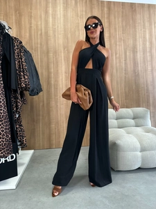 Detail view of black halter neck jumpsuit with cutout waist and wide leg silhouette