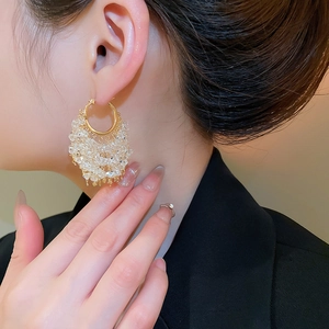 Detailed view of 18k gold plated hoop earrings with cascading crystal tassels on a model