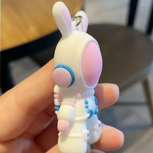 Close-up of white space rabbit keychain with silicone texture and colorful accents