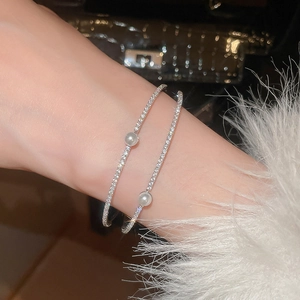 Detail of double-layer zircon pearl bracelet with silver finish on female wrist