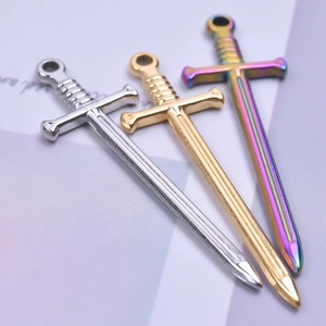 Macro detail of three fence-shaped steel pendants in silver, gold, and rainbow finishes