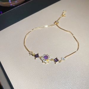 Macro shot of gold adjustable bracelet with purple gemstones and shimmering zircons