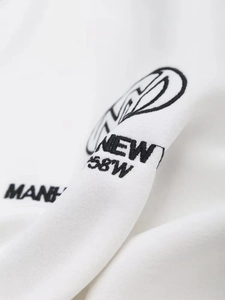 Close-up of black text embroidery NEW 58W on white cotton long sleeve sweatshirt