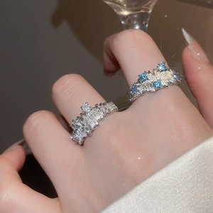 Detailed shot of irregular geometric open rings with blue and white zircon stones