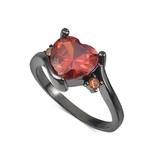 Macro view of heart-cut red gemstone on black plating ring with orange side stones