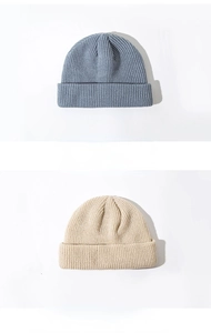 Detailed close-up showing the fine knit texture of grey and beige short beanie hats