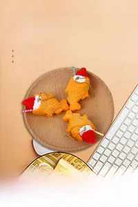 Close-up of three miniature realistic taiyaki fish cakes with cream and strawberry toppings