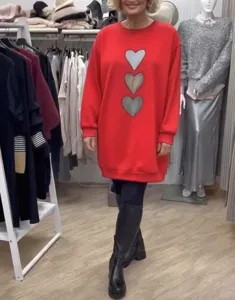 Detalle del vestido sudadera rojo de manga larga con estampados de corazones y ajuste holgado