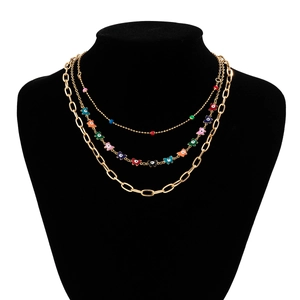 Three-layer layered necklace featuring colorful butterfly and evil eye charms on gold chains