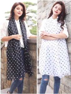 Detailed view of lightweight black and white polka dot scarves in a soft chiffon fabric