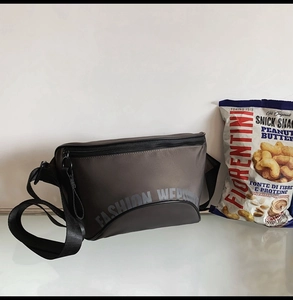 Détail du sac bandoulière utilitaire gris foncé avec tissu synthétique et fermeture