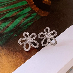 Détail macro de boucles d'oreilles fleurs argentées avec incrustation de zircons