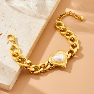 Close-up of a chunky gold chain bracelet featuring a heart-shaped pearl pendant