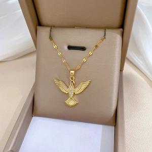 Detail of gold bird pendant necklace with sparkling crystals in a beige jewelry box