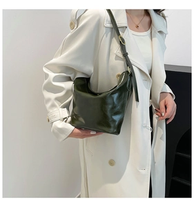 Detail of dark green glossy leather shoulder bag with metallic adjustable buckle