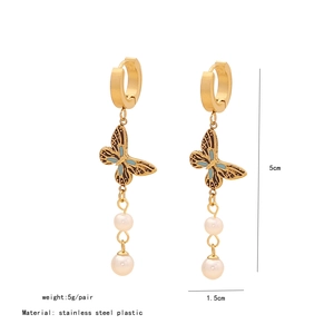 Vue détaillée des boucles d'oreilles papillon dorées avec perles et émail bleu