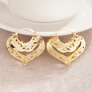 Elegant gold hollow heart earrings with intricate woven texture and hoop closure design